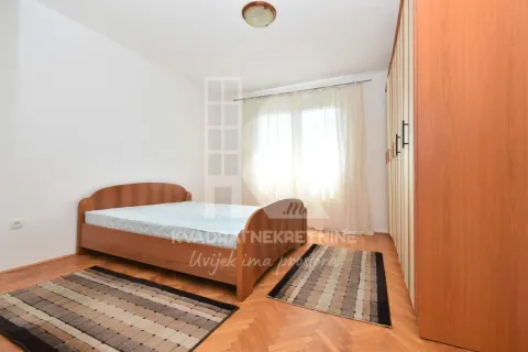 Furnished bedroom with a double bed and a large wooden wardrobe. - image 6