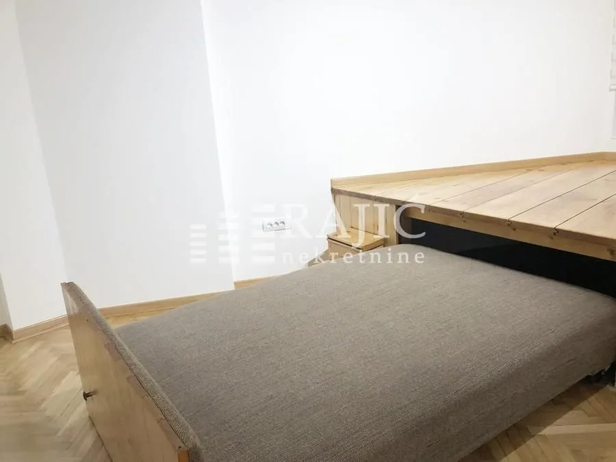 Smaller bedroom with a bed and a wooden platform.