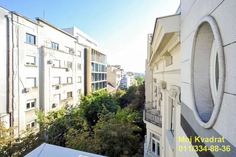 View from the terrace towards surrounding buildings and greenery in the street.