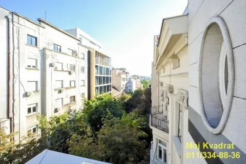 View from the terrace towards surrounding buildings and greenery in the street. - image 12
