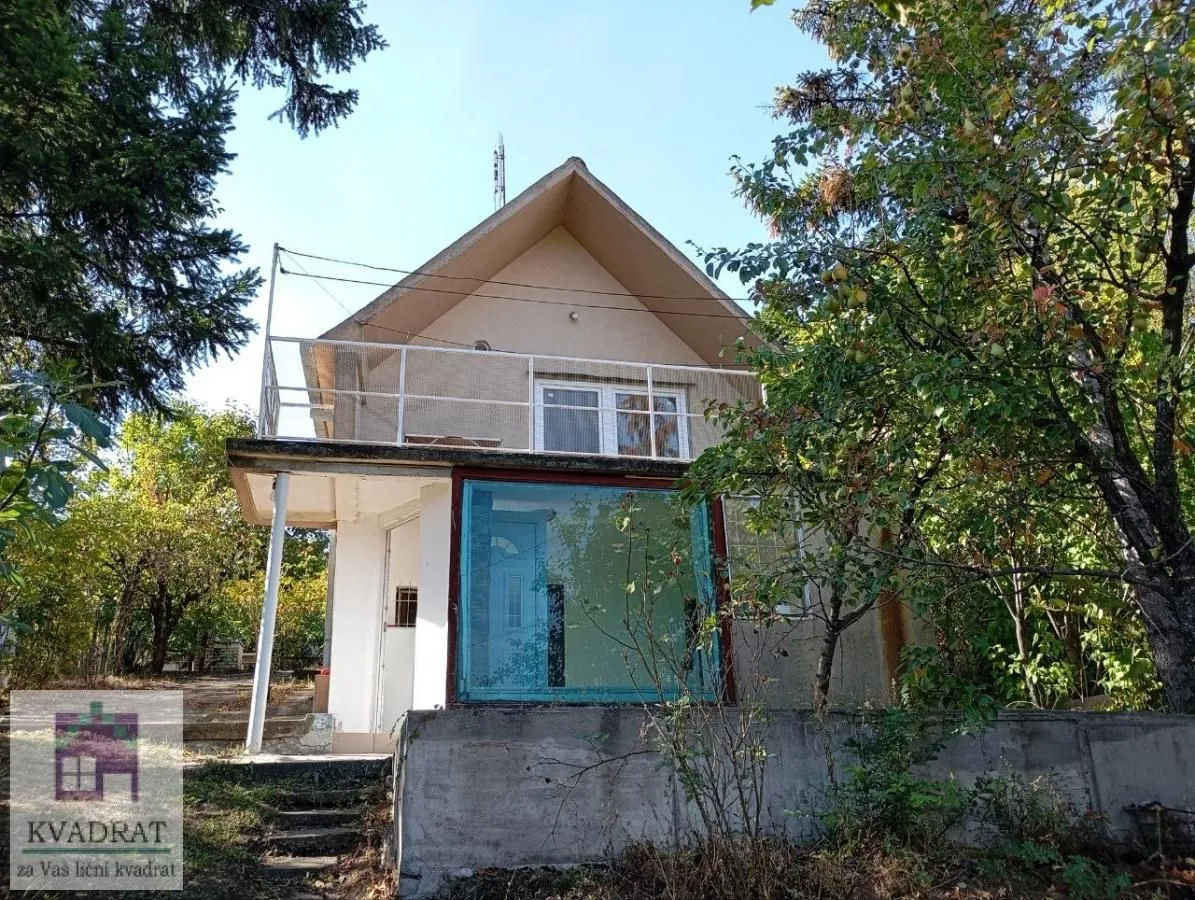 Pogled na spoljašnjost kuće sa dvorištem i terasom.