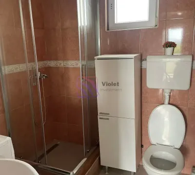 Bathroom with a shower cabin, toilet, and a white bathroom cabinet. - image 14