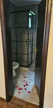 Pogled kroz otvorena vrata na moderno uređeno kupatilo sa tuš kabinom. - image 8