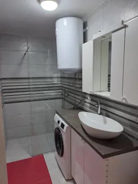 Modern bathroom with a glass shower cabin, washing machine, and boiler. - image 3