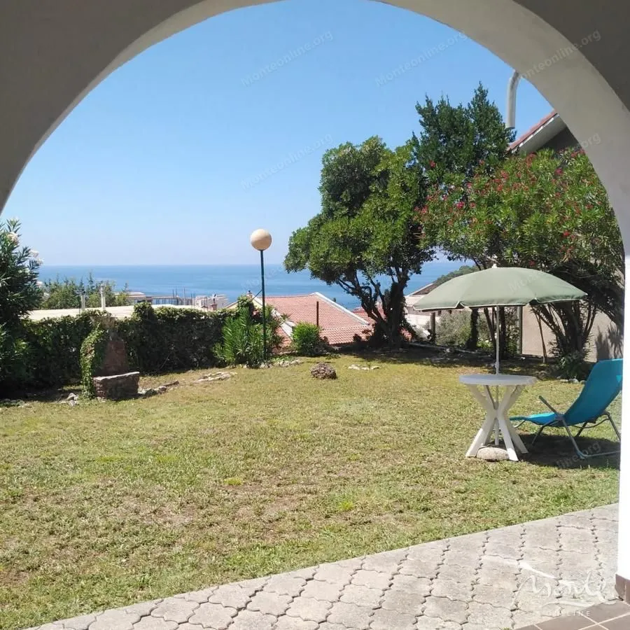 Green yard with a sea view and patio furniture.