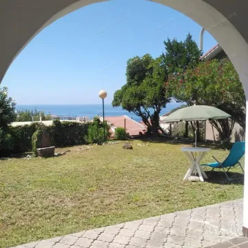 Green yard with a sea view and patio furniture. - image 6