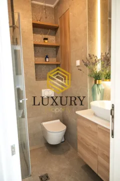 A modern bathroom equipped with a walk-in shower, toilet, and vanity sink. - image 3