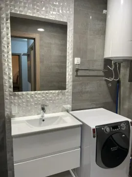 Moderno kupatilo sa lavaboom, ogledalom i veš mašinom. - image 8