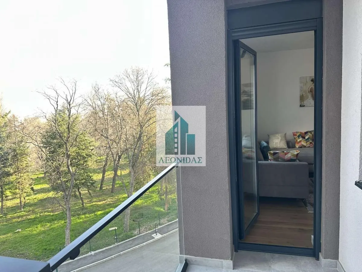 Balkon sa pogledom na park i pogledom na unutrašnjost stanovanja.
