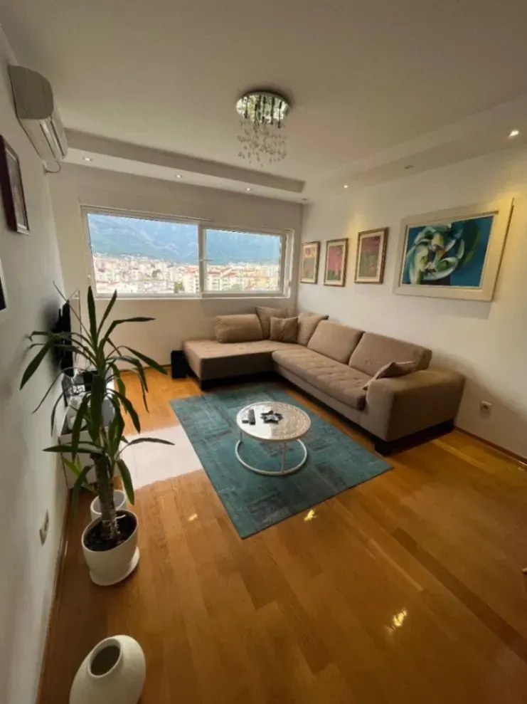 Living room with a sectional sofa, coffee table, and a window with a city view.