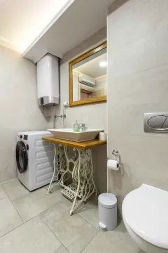 Kupatilo opremljeno umivaonikom na postolju od stare šivaće mašine, veš mašinom i bojlerom. - image 5