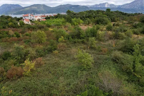 Zeleni građevinski plac okružen prirodom sa pogledom na planine i more u daljini. - image 12