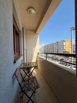 Manji namješteni balkon sa stolom i dvije stolice i pogledom na naselje. - image 7