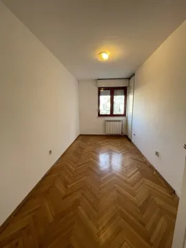 An empty room with parquet flooring and a window. - image 5