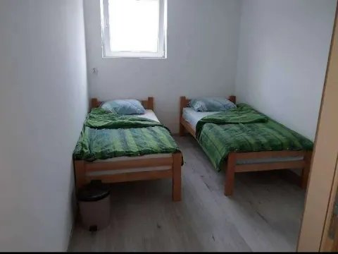 Manja spavaća soba sa dva drvena kreveta. - image 5
