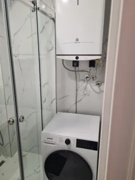 Part of a bathroom with a washing machine and water heater. - image 12