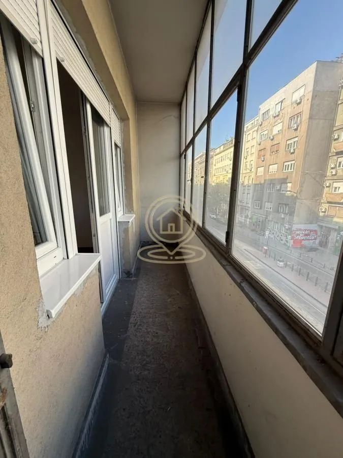 Zastakljeni balkon sa pogledom na ulicu.