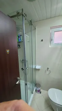 Compact bathroom with a shower cabin and toilet. - image 8
