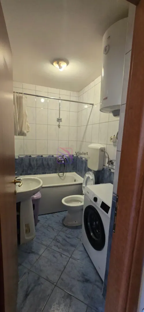 Manje kupatilo sa kadom, umivaonikom, toaletom i veš mašinom.