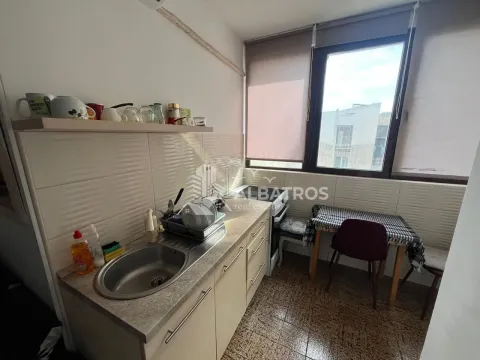 Manja kuhinja sa sudoperom, radnim elementima i trpezarijskim stolom pored prozora. - image 3