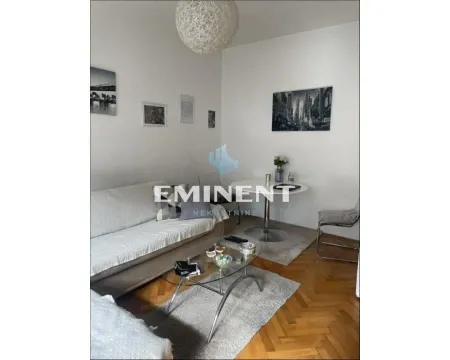 Living room with a sofa, glass coffee table, and dining table with a chair. - image 10