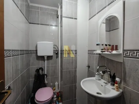 Manje kupatilo obloženo keramičkim pločicama sa umivaonikom, ogledalom i toaletom. - image 5