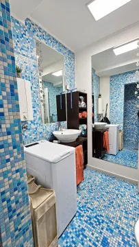 Bathroom with blue mosaic tiles, washbasin and washing machine. - image 15