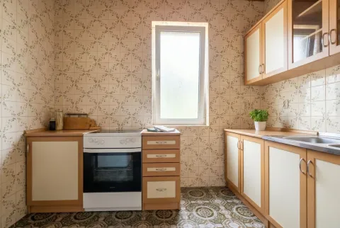 Kuhinja sa retro pločicama, šporetom i drvenim elementima. - image 9