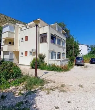 Pogled na spoljašnjost zgrade sa parkingom i zelenilom. - image 2