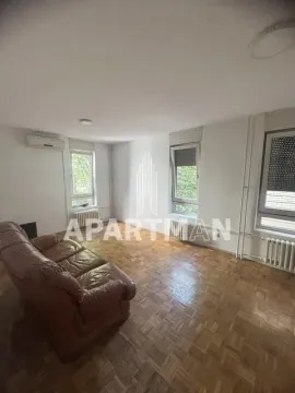 Living room with parquet flooring and leather sofa. - image 2