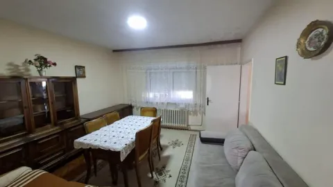 Dnevna soba sa garniturom za sedenje, trpezarijskim stolom i drvenom vitrinom. - image 8