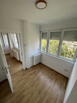 Prazna soba sa parketom i prozorima koji gledaju na zelenilo. - image 10