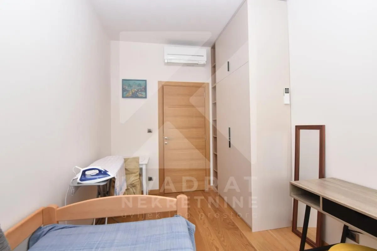 Smaller bedroom with a bed, built-in wardrobe, and desk.