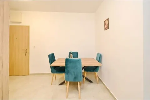 Dining area with a wooden table and blue chairs. - image 4