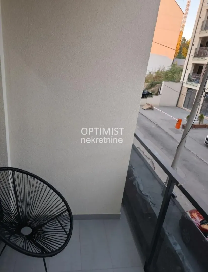 Manji balkon sa stolicom i pogledom na ulicu.