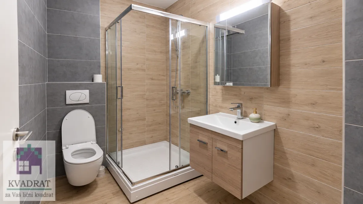Moderno opremljeno kupatilo sa tuš kabinom, umivaonikom i WC šoljom.