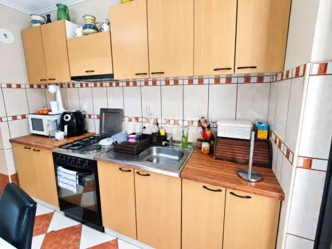 Kuhinja sa drvenim elementima, sudoperom i ugrađenim šporetom. - image 4