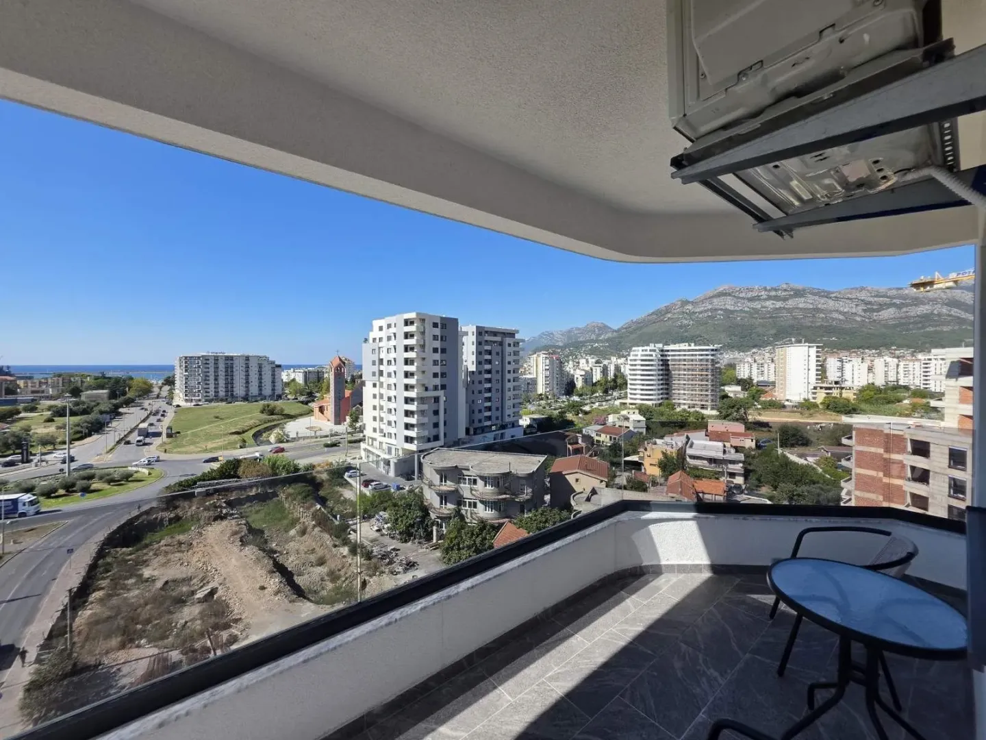Balcony with seating furniture and a view of the city and surroundings.