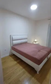 Uređena spavaća soba sa bračnim krevetom i drvenim podom. - image 5