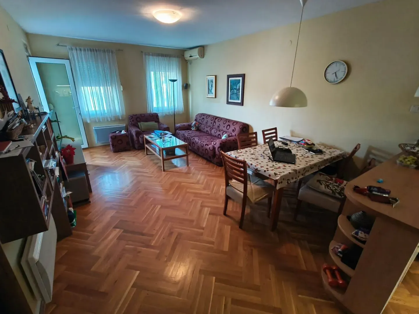 Dnevni boravak sa garniturom za sjedenje i trpezarijskim stolom.