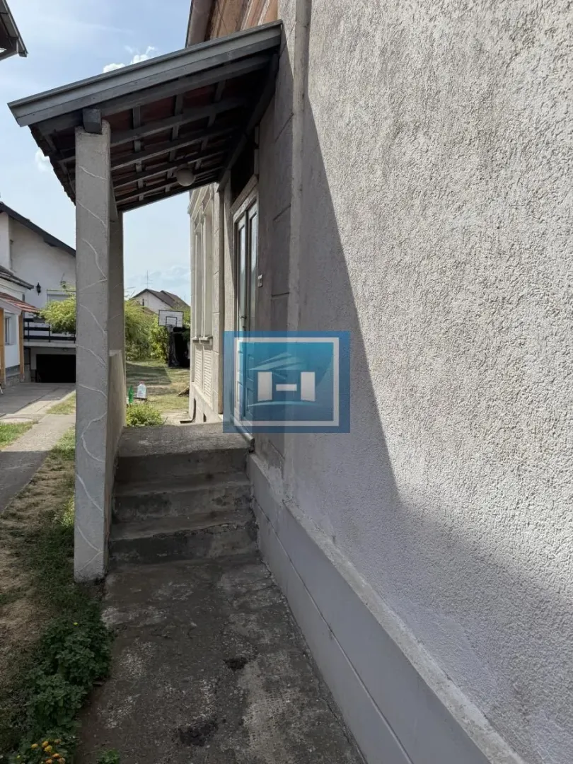 Ulaz u kuću sa natkrivenim tremom i spoljnim stepenicama.