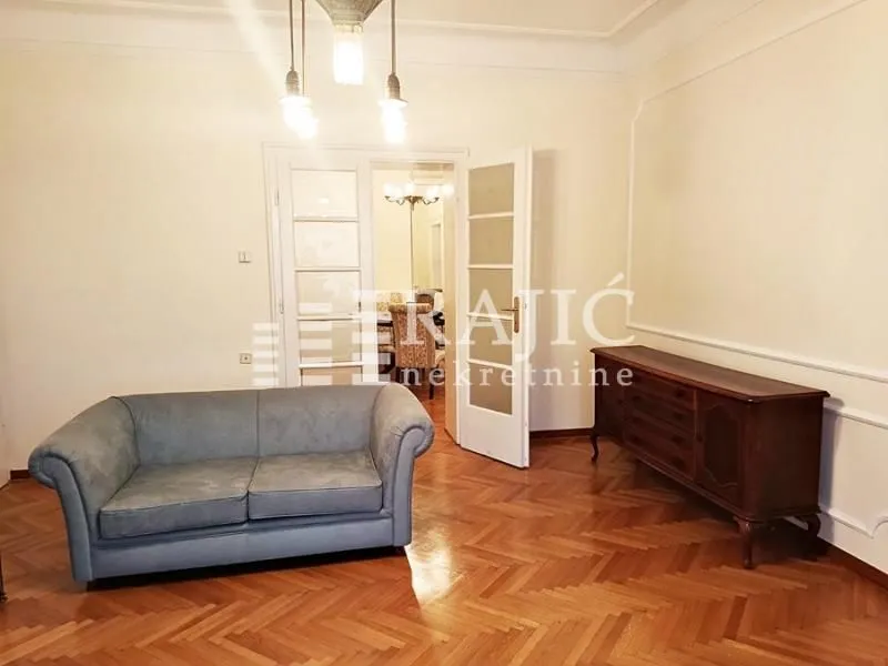 Spacious living room with seating furniture and a view into the dining area.