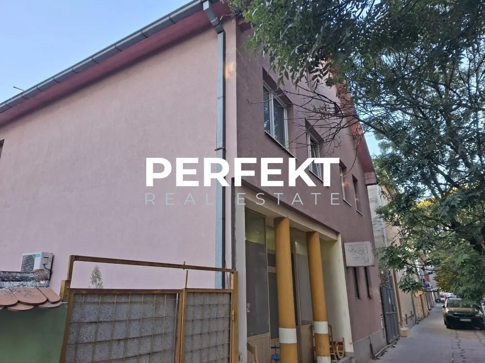 Pogled na spoljašnjost zgrade sa ulazom i ulicom.