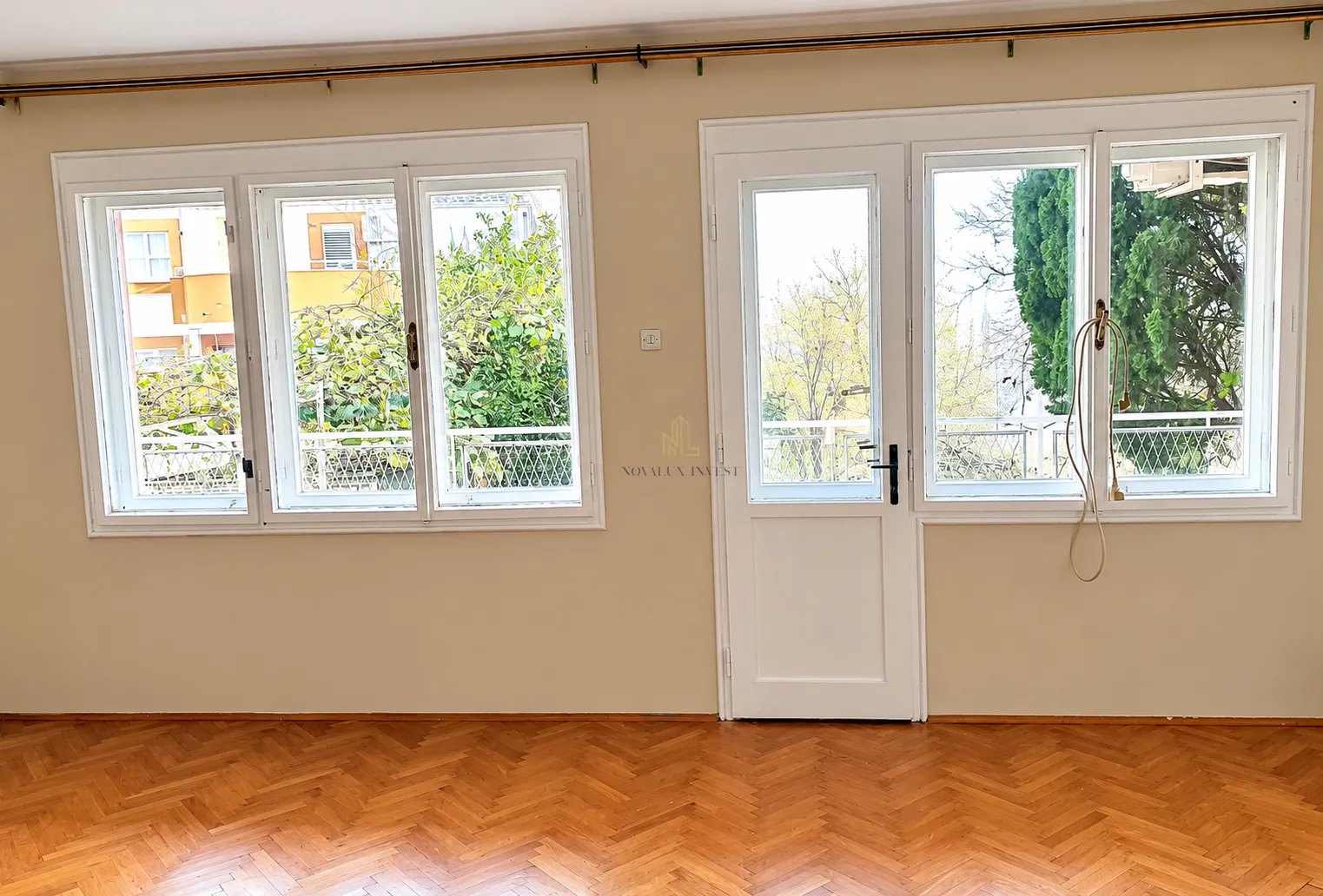 Empty room with parquet flooring and access to the terrace.