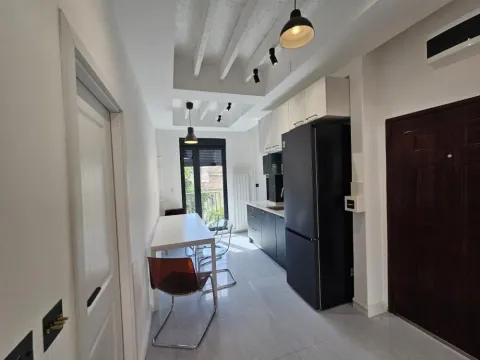 Modern kitchen with a dining table and a black refrigerator. - image 5