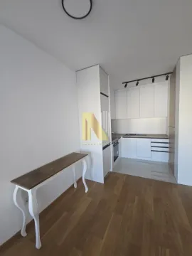 Moderna bela kuhinja u sklopu manjeg prostora sa drvenim podom. - image 7