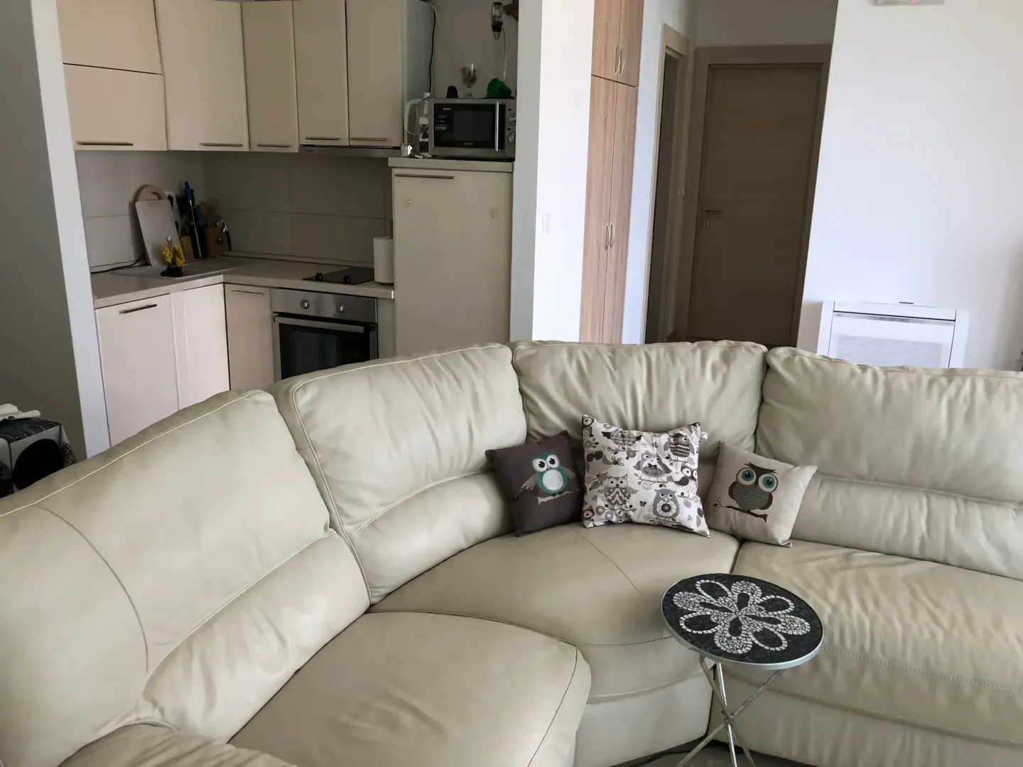 Living room with a sectional sofa and a view of the kitchen.