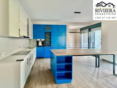 Modern kitchen with white and blue cabinets and a large dining table. - image 11