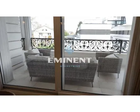 Covered terrace with seating furniture and a view of surrounding buildings. - image 18
