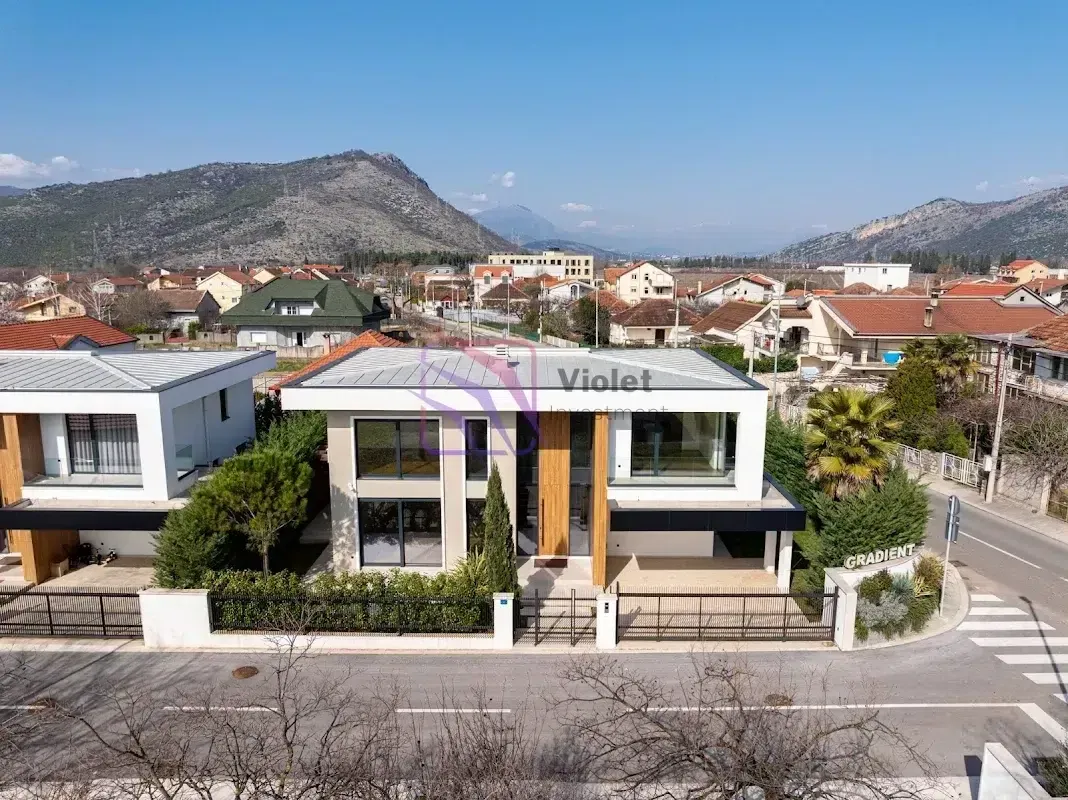 Pogled iz vazduha na modernu porodičnu kuću sa dvoriijem i okruženjem.